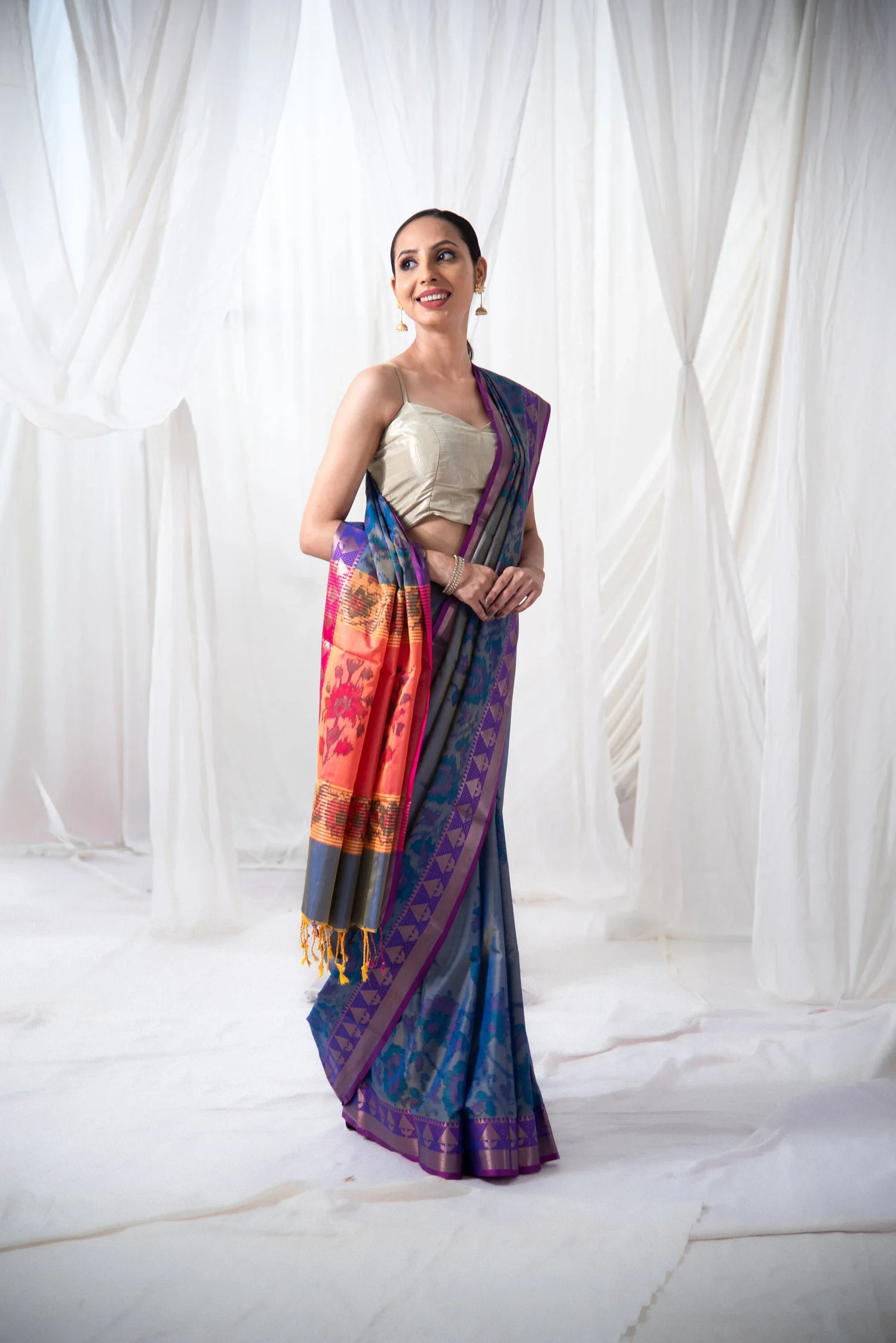 Woman in traditional blue and magenta Banarasi Ikkat silk saree with geometric patterns