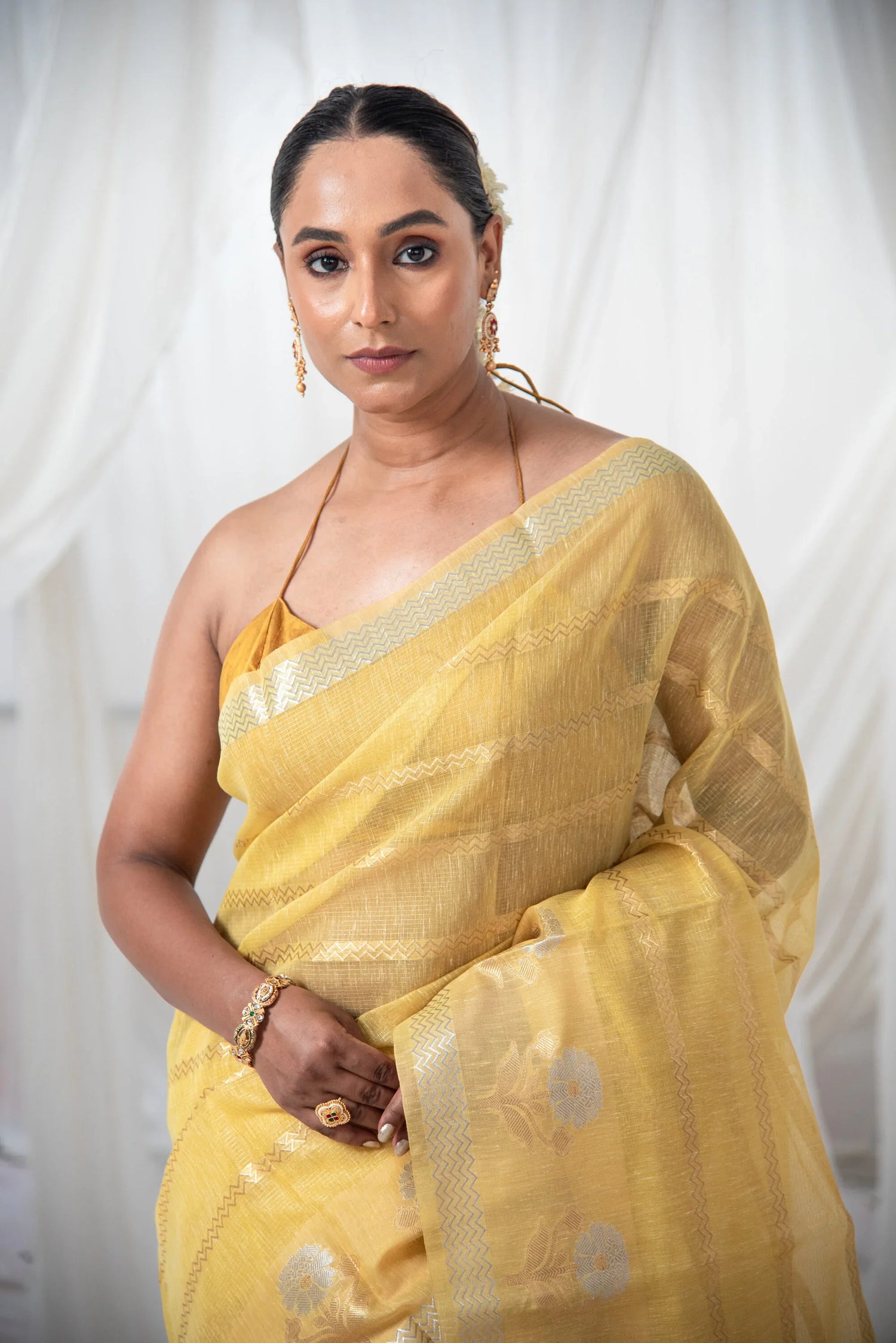 Woman in a gold yellow Banarasi cotton linen silk saree with silver zari details