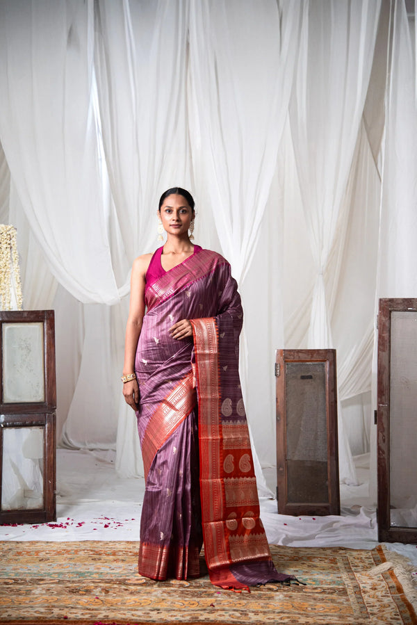 Woman wearing a dual-tone Banarasi cotton saree with zari border in a minimal indoor setting — alternate view (back / drape detail)