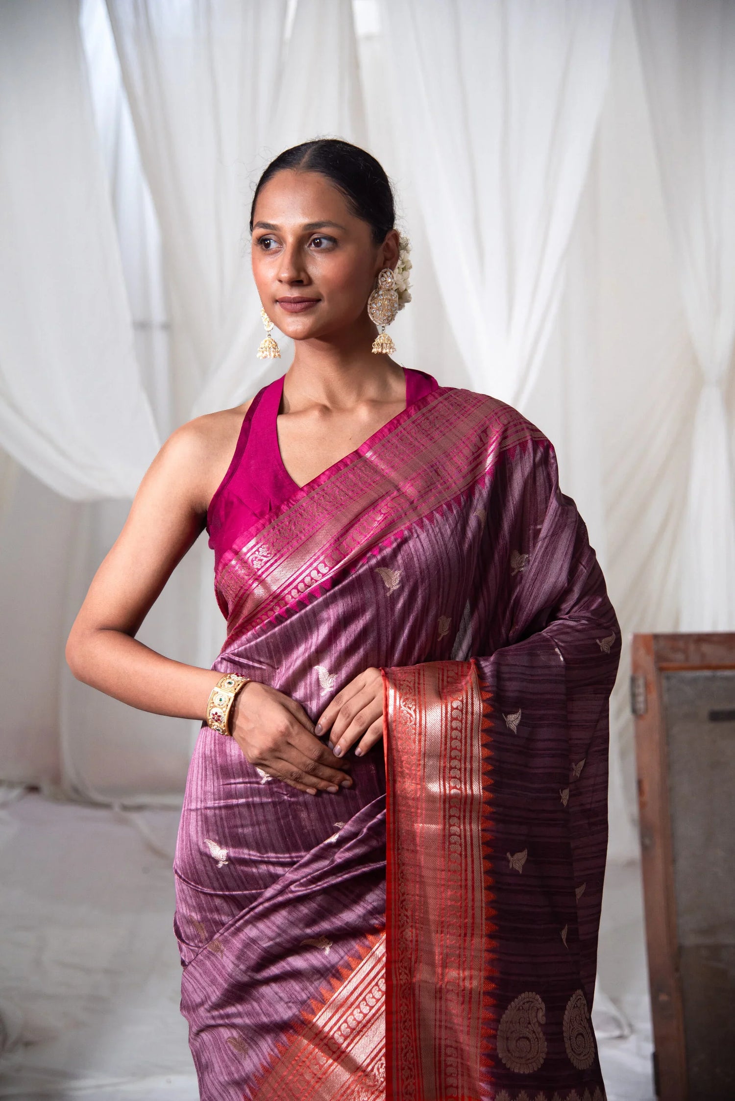 Woman in a purple Banarasi cotton saree with dual-tone border and traditional jewelry