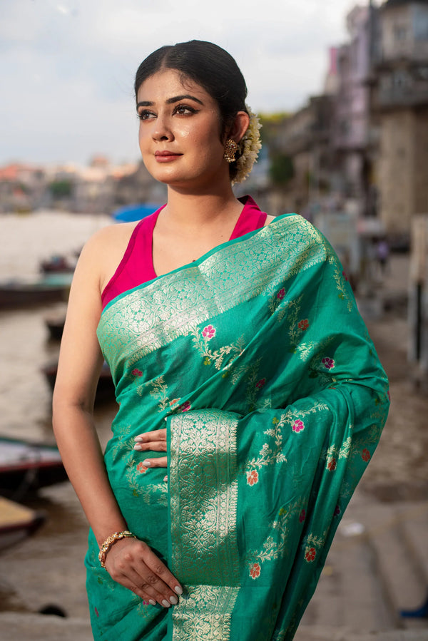 Woman in a teal Banarasi silk saree with meenakari floral motifs and gold zari border — alternate view (back / drape detail)