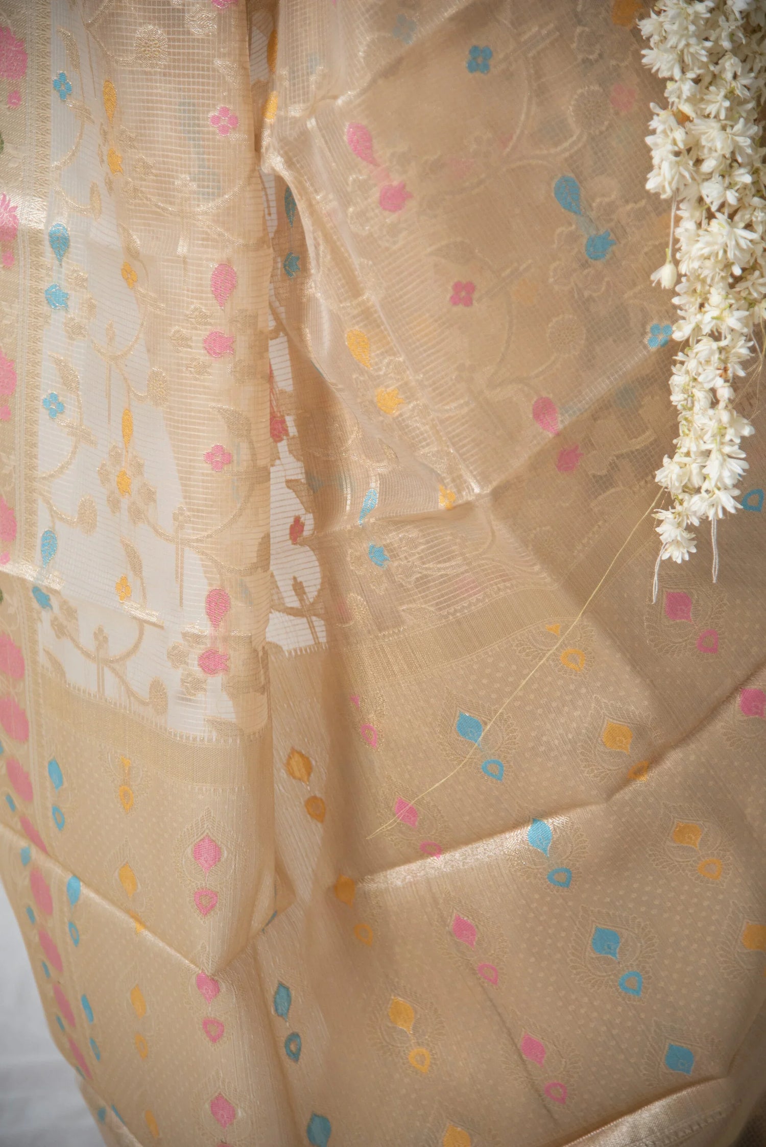 Beige Banarasi Kota organza saree with colorful meenakari floral patterns and white flowers