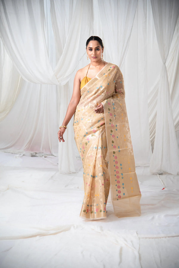 Woman wearing beige Banarasi kota organza saree with colorful meenakari floral motifs